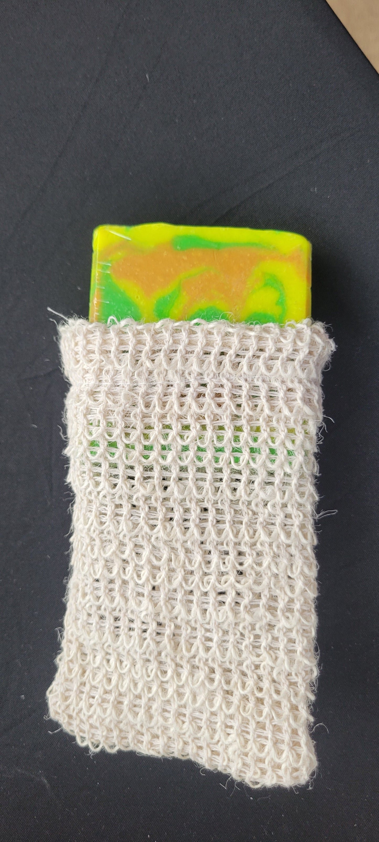 Rectangular woven fabric sample with a colorful label on a black background